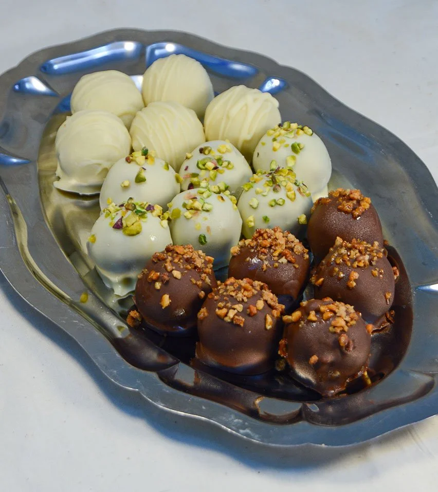 Imagen de los delis de varios sabores, que son bolitas de un solo bocado de masa de bizcocho con distintos sabores, cubiertos con chocolate y decorados.