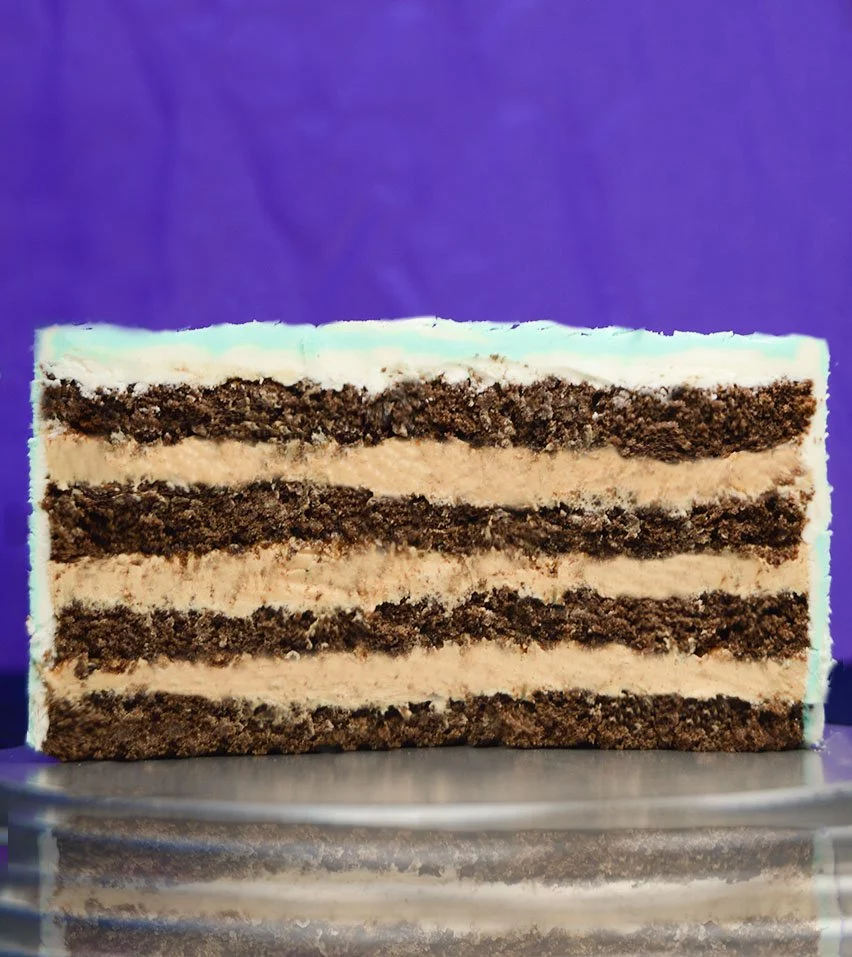 Imagen del corte transversal de la tarta de Kinder bueno con bizcocho de chocolate. En la imagen se puede ver el interior de la tarta, formada por cuatro capas finas de bizcocho de chocolate esponjoso y tres rellenos abundantes y cremosos de Kinder bueno.