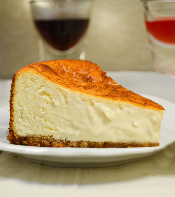 Imagen corte de tarta de queso clásica. Con base de galleta crocante, interior muy cremoso y tostada por arriba, al estilo vasco.